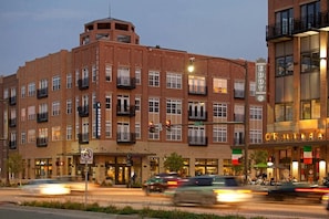 A multi-story building with a brick facade, multiple balconies, and storefronts. - Walk to Notre Dame Stadium & Campus - Luxury 1BR, Sleeps 4 (South Bend)