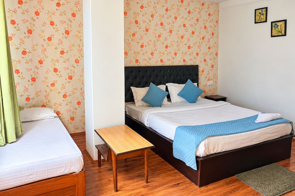 A bedroom with a bed, a bedside table, a bench, and a small rug.