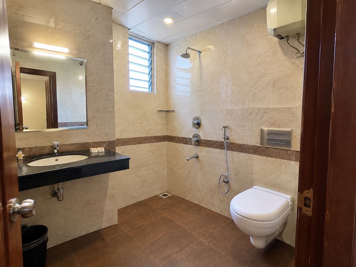 A bathroom with a sink, mirror, shower, and toilet.