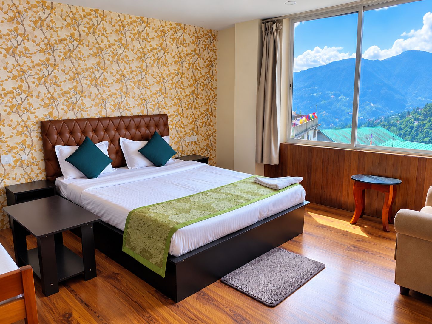 Une chambre d’hôtel avec un grand lit, une vue sur les montagnes, un plancher en bois et une petite table.
