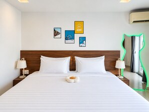 A hotel room with a large bed, two bedside tables with lamps, a wall-mounted air conditioner, and framed pictures. - Moc An Collection - Mermaid Seaside VT (Vung Tau)