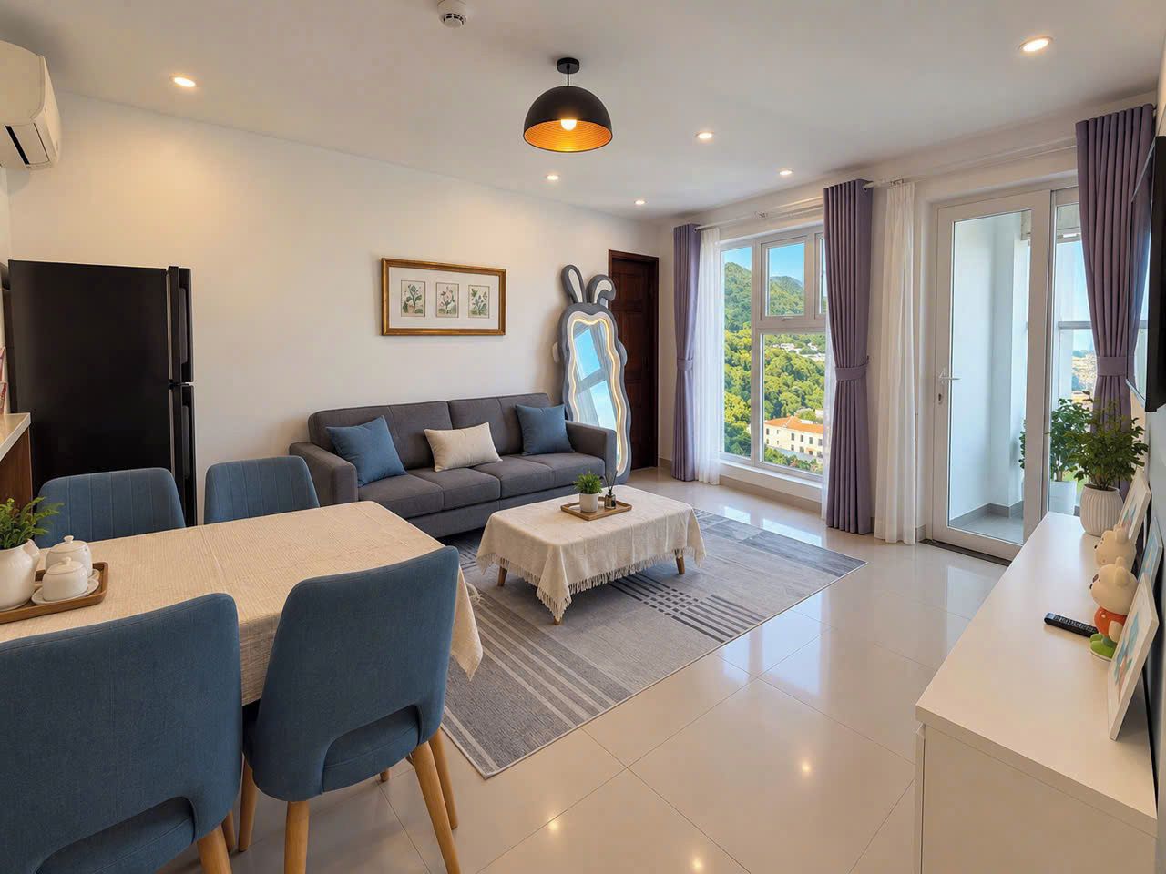 A modern living room with a sofa, dining table, and a large window with curtains.