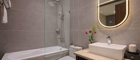 A modern bathroom with a bathtub, toilet, and sink.