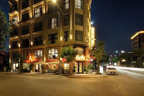 Un hotel de varios pisos con terraza exterior y fachada luminosa.