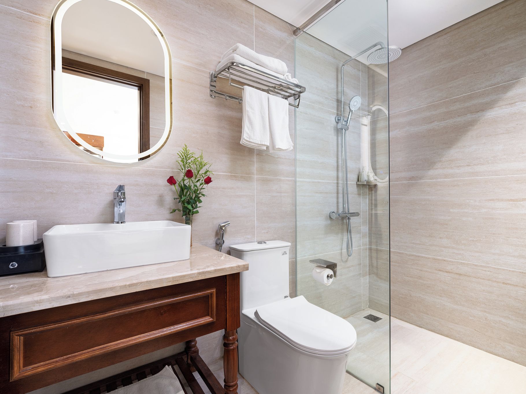 Ein modernes Badezimmer mit großem Spiegel, Waschbecken, Toilette und einer Duschkabine.