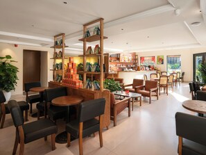 Una cafetería con mobiliario de madera, una barra de café y estanterías con productos de café.