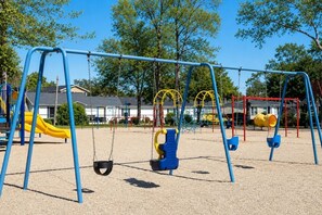 Ein Spielplatz mit Schaukeln und einer Rutsche.