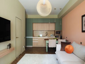 Una sala de estar moderna con un sofá, un televisor y un comedor con sillas y una mesa.