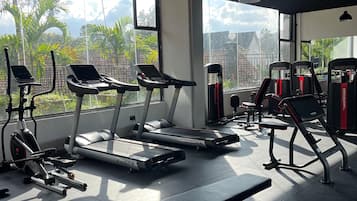 A gym with treadmills, weight machines, and benches.