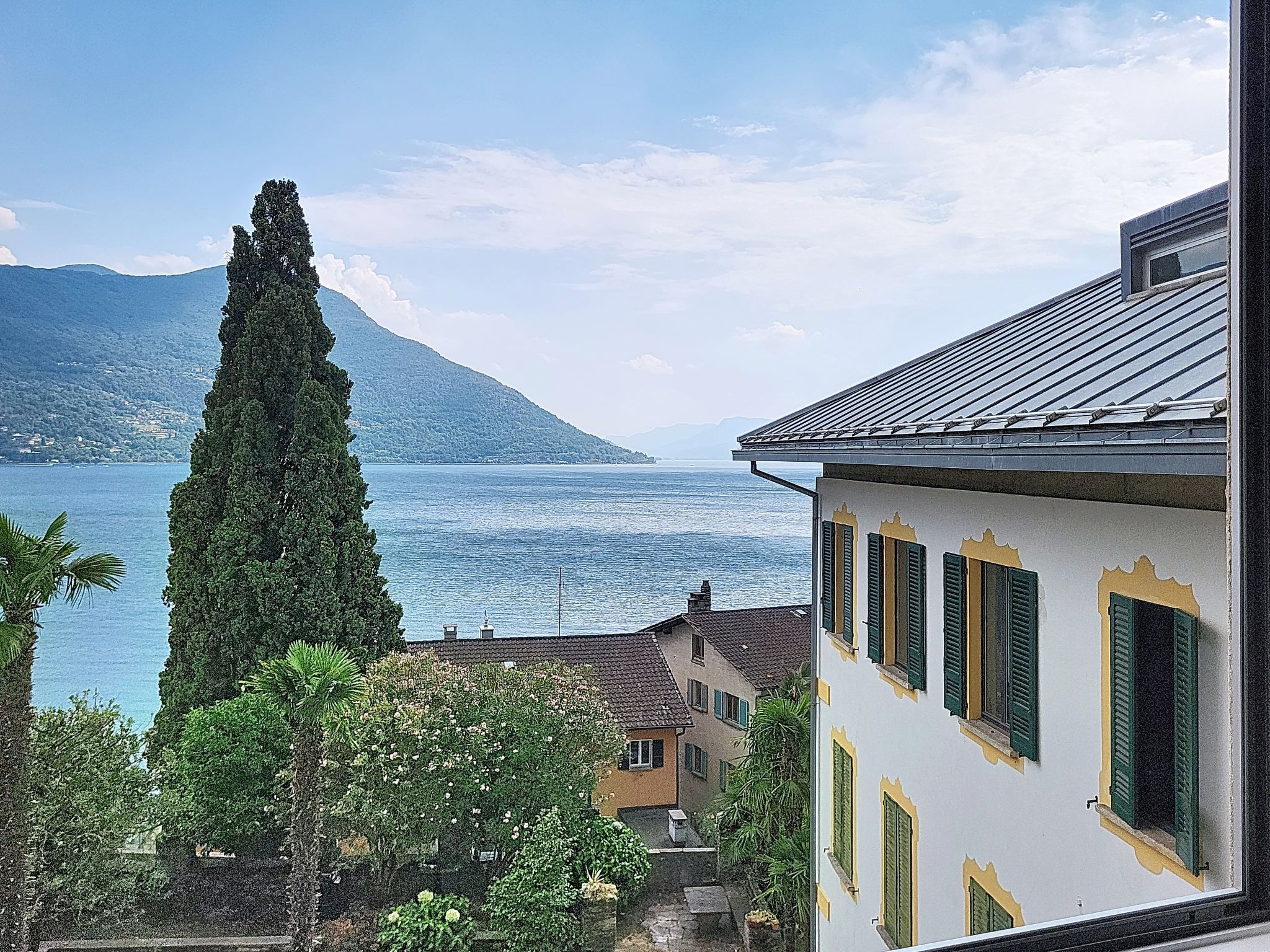 A coastal building with a view of the sea and mountains.