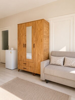 A room with a wooden wardrobe, a white sofa, and a small white appliance. - 3BR Istanbul Apartment In Historic Balat + Golden Horn Views (Istanbul)