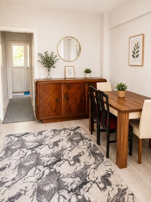 A dining area with a wooden table, chairs, a cabinet, a mirror, and a rug. - 3BR Istanbul Apartment In Historic Balat + Golden Horn Views (Istanbul)