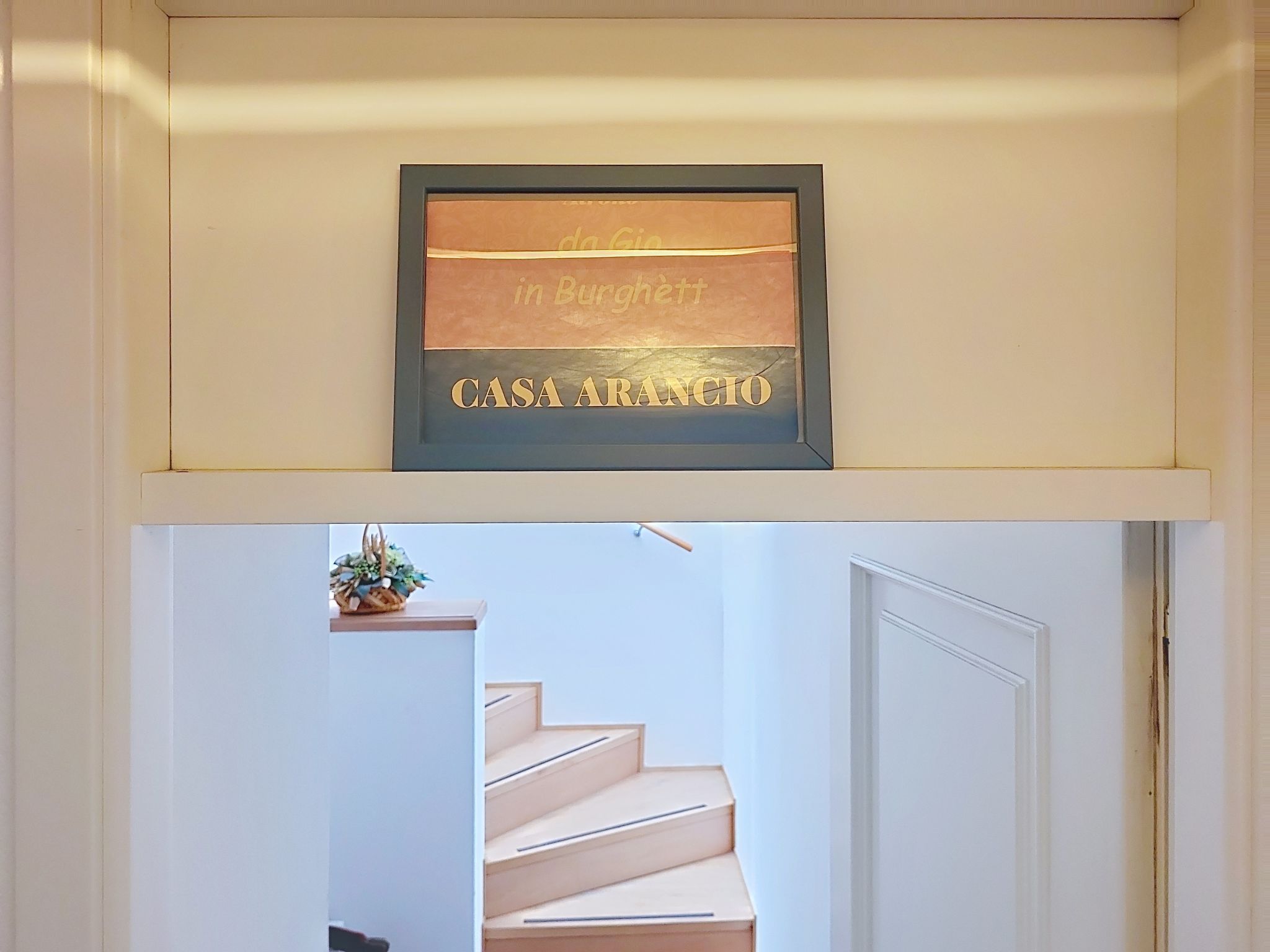 Une plaque encadrée avec une inscription, placée au-dessus d’un escalier.