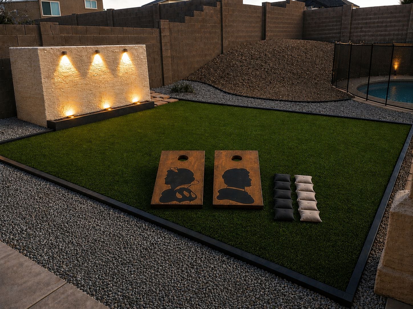 Ein gepflegter Gartenbereich mit Kunstgrasanlage, einer Zierwand mit Beleuchtung und einem Pool.