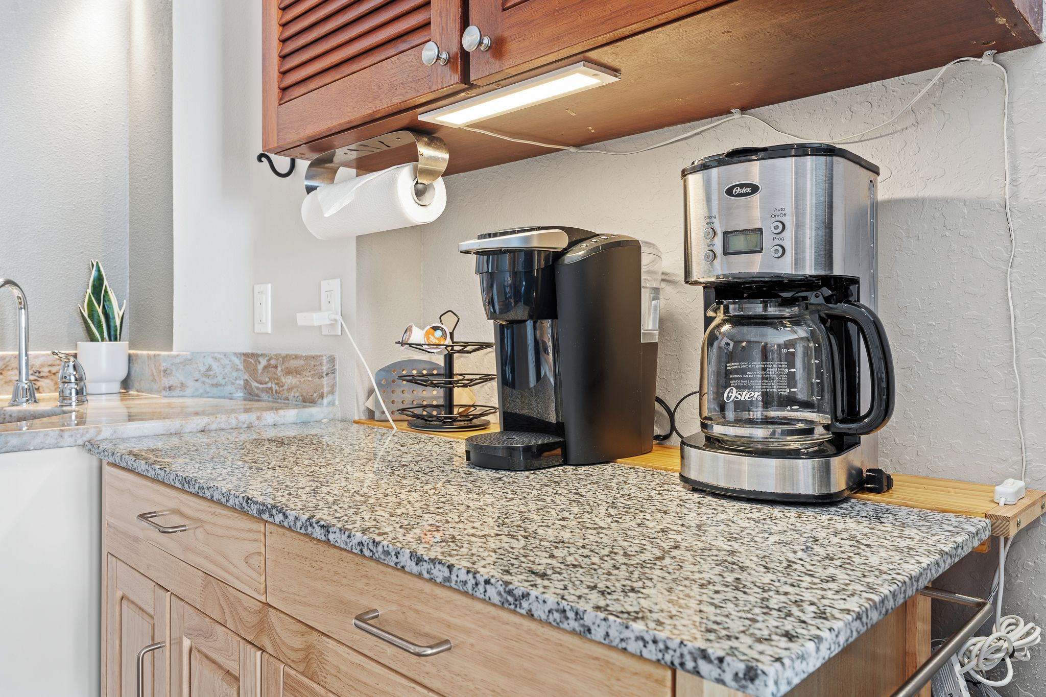 A kitchen with granite countertops, a coffee maker, and a toaster.