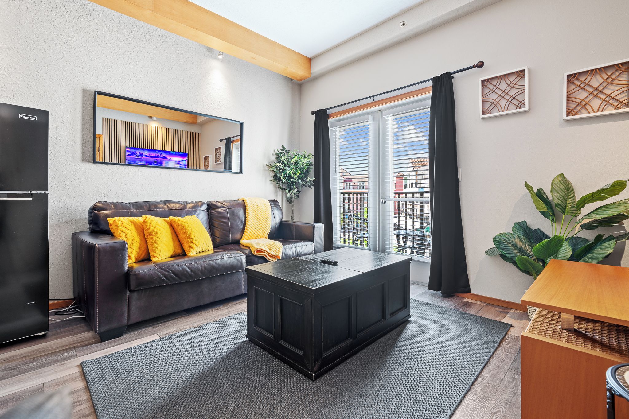 Una sala moderna con sofá, mesa de centro y vistas al balcón.