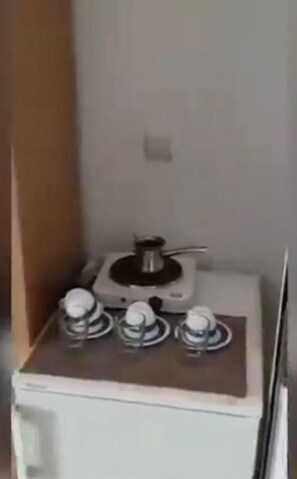 Una kitchenette pequeña con estufa a gas y microondas.