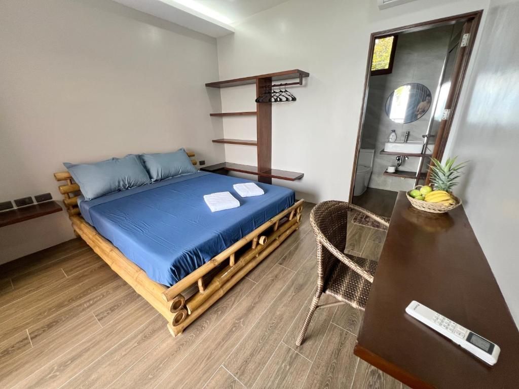 A room with a bed, a chair, a shelf, and a mirror.