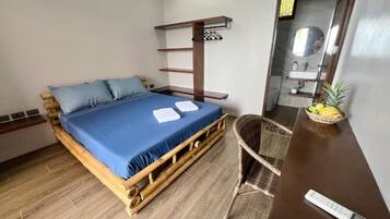 A room with a bed, a chair, a shelf, and a mirror.