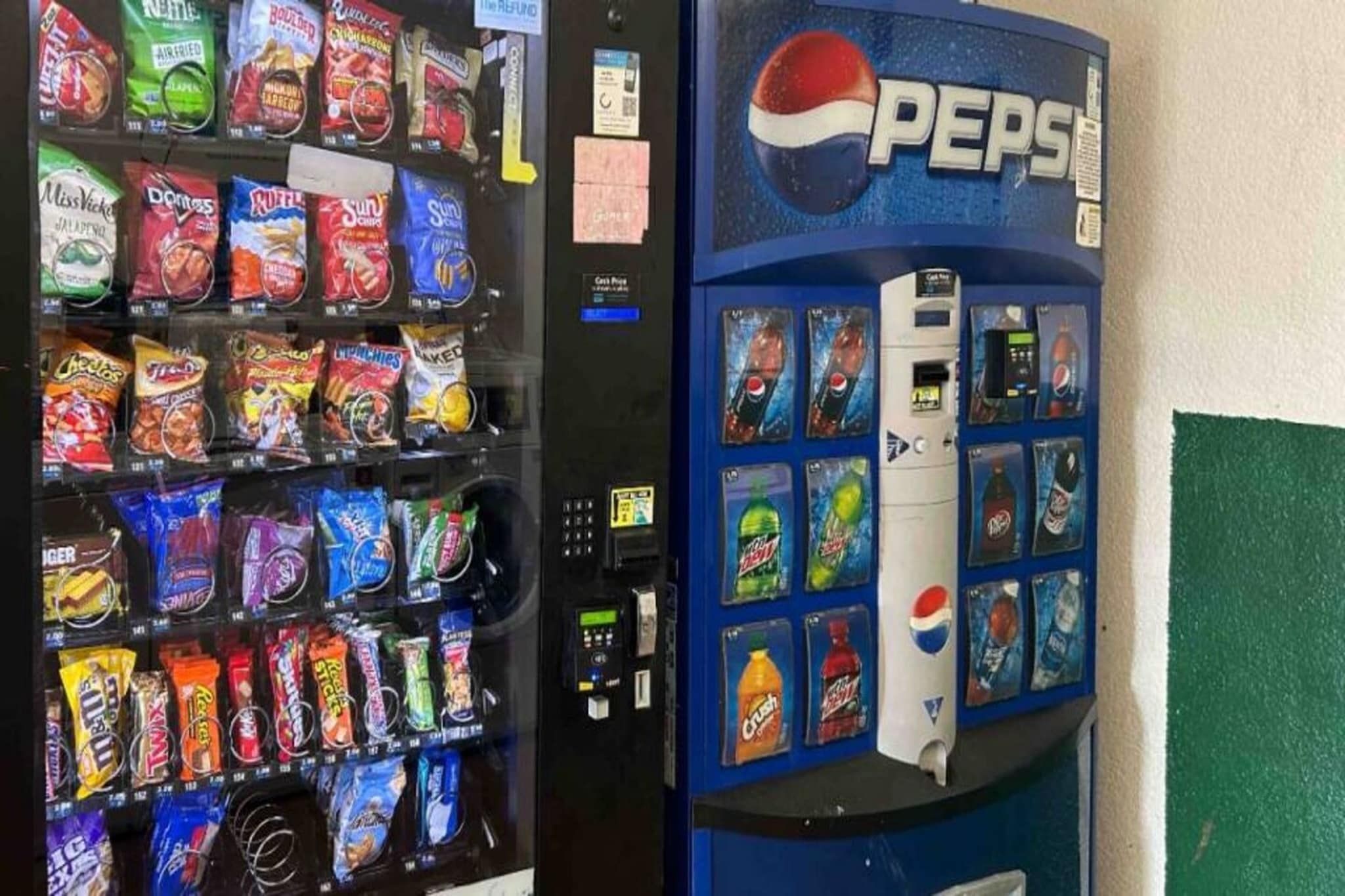 Máquina de vendas com lanches e um dispensador de Pepsi.