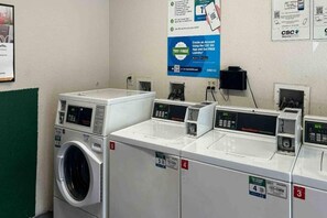 Une laverie équipée de plusieurs machines à laver et de plusieurs séchoirs, chacun étant identifié par un numéro.