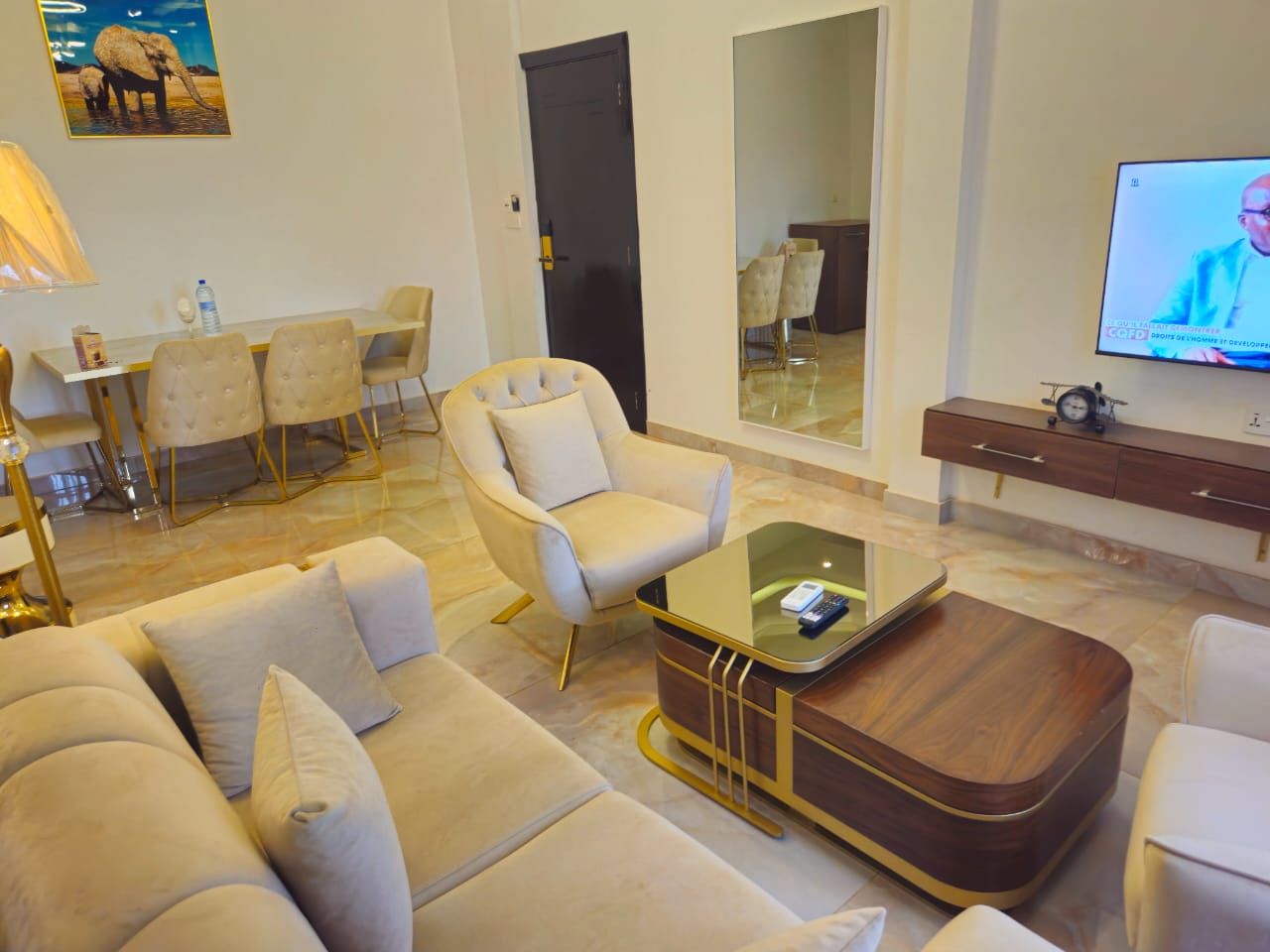 Una sala de estar moderna con sofá, sillón, mesa de centro y televisor.