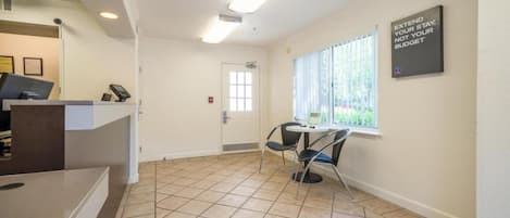 A reception area with a counter, a door, and a window with blinds.