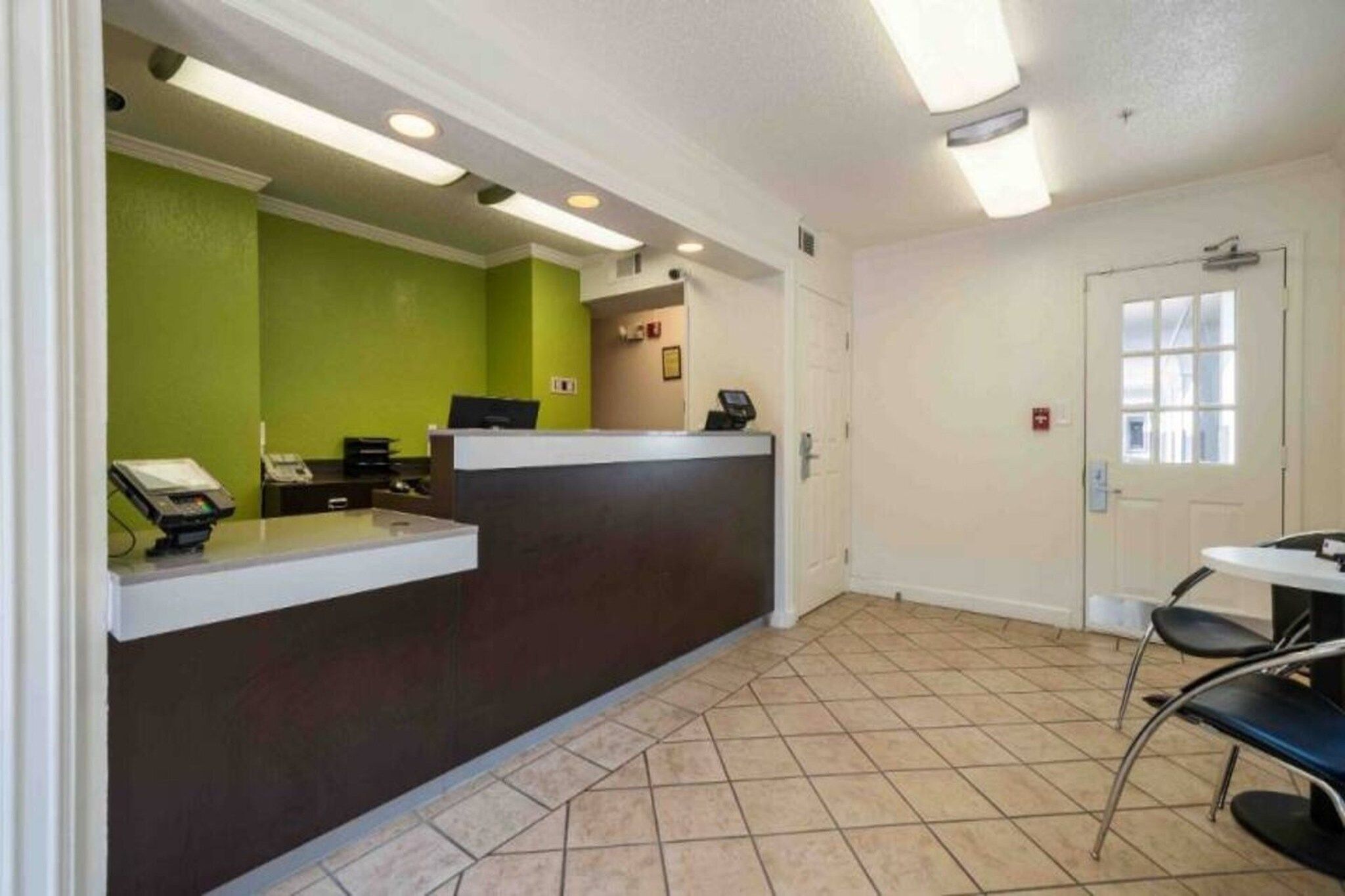 A reception area with a counter, a phone, and a door.