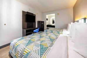 A hotel room with a bed, a desk, a chair, a television, and a mirror. - 2 Queen Beds | Smoking (Fort Worth TX)