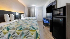 A hotel room with a bed, a desk, a chair, a TV, and a refrigerator. - 2 Full Beds | Non-Smoking (Fort Worth TX)