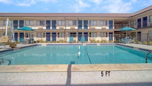 A hotel with a swimming pool, outdoor seating, and a multi-story building. - 1 Full Bed | Premium, Mini Fridge (Venice)