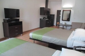A hotel room with two beds, a desk, a chair, a television, and a wardrobe.