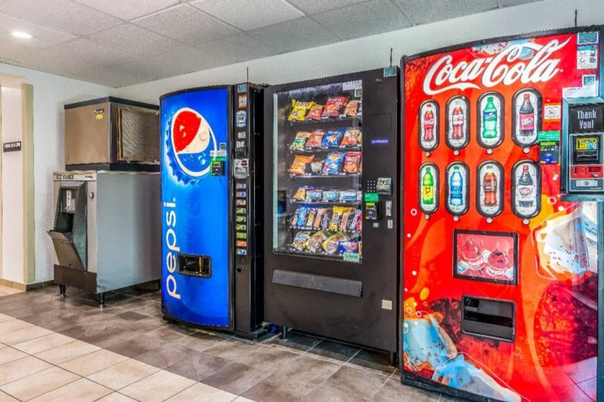 Automatische verkoopapparaten met Pepsi- en Coca-Cola-logo's, en een magnetron.