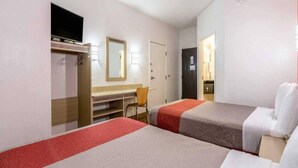 A hotel room with two beds, a desk, a chair, and a television. - Spacious 1 Queen Bed Non-Smoking (Fort Mill)