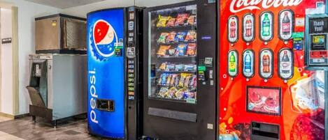 Automat med Pepsi og Coca-Cola logoer, en vanddispenser og en skraldespand.