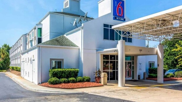 Motel 6 con entrada despejada, zona de estacionamiento techada y fachada bien conservada.