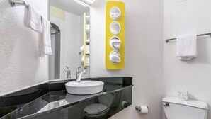 Un baño con lavabo, inodoro y espejo.