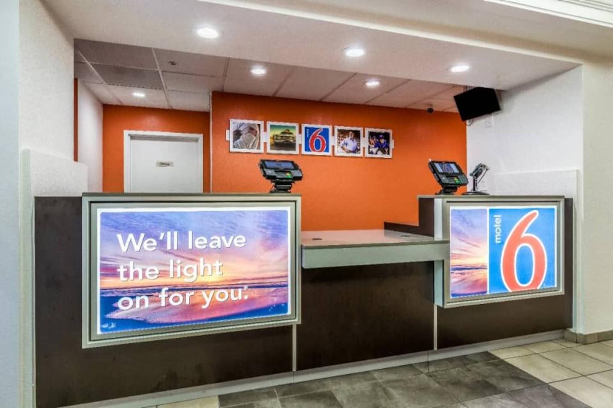 A hotel reception desk with a sign that reads 'We'll leave the light on for you.'