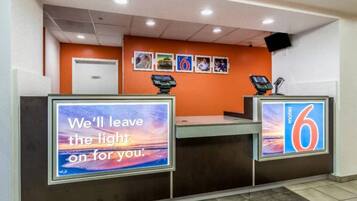 A hotel reception desk with a sign that reads 'We'll leave the light on for you.'