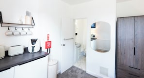 A modern kitchen with a toaster, kettle, and a fire blanket sign.