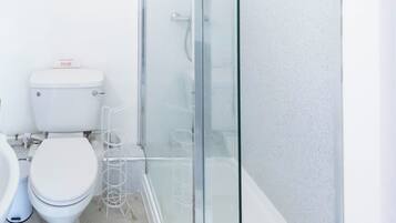 A modern bathroom with a glass-enclosed shower, a toilet, and a bidet.
