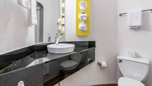 Un bany modern amb un lavabo blanc, un vàter i un mirall.
