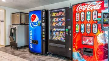 Automaten met Pepsi en Coca-Cola reclame, een waterkraan en een afvalbak.