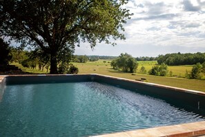 A swimming pool with a view of a rural landscape.