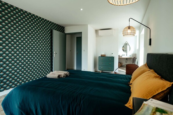 A bedroom with a bed, a dresser, a chair, and a desk.