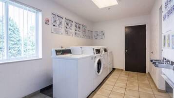 A laundry room with a washing machine, dryer, and a door leading to another room.