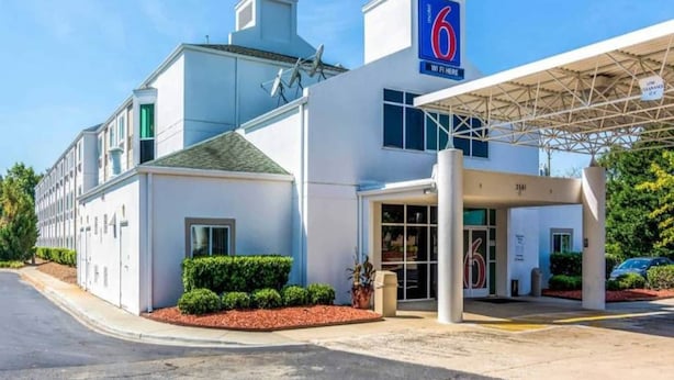 Motel 6 con entrada despejada, zona de estacionamiento techada y fachada bien conservada.