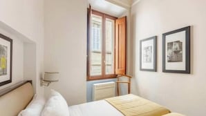 Ein Hotelzimmer mit Bett, Fenster mit Blick und gerahmten Bildern an der Wand.