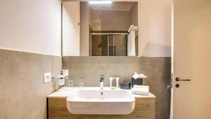 Ein Badezimmer mit Waschbecken, Spiegel und Dusche.