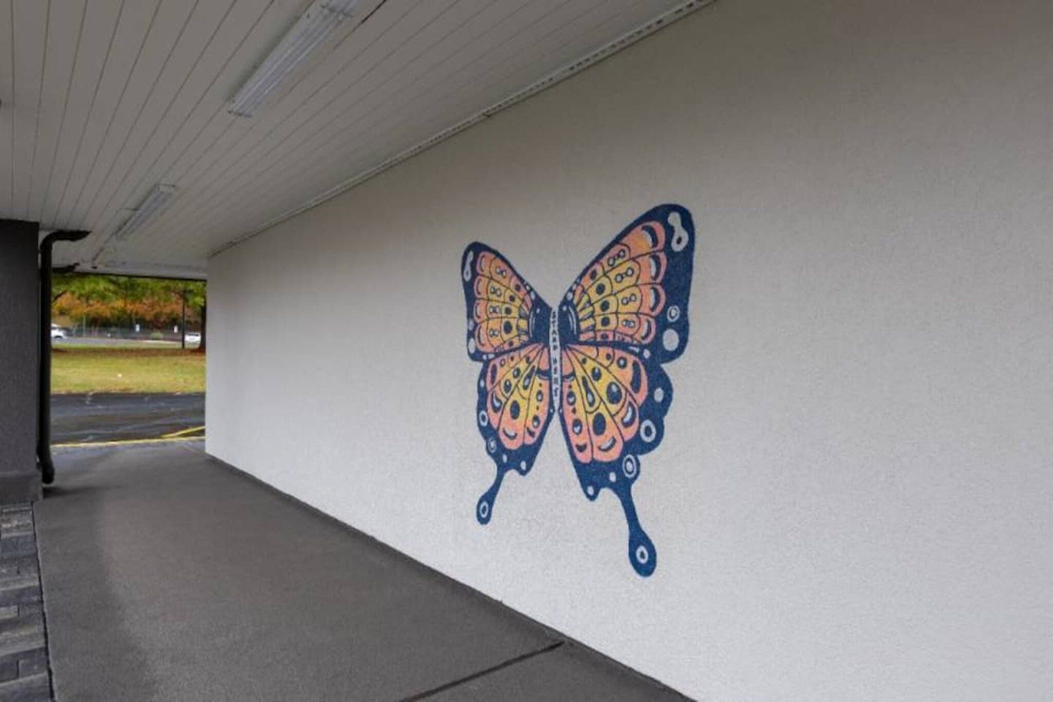 Paredes com um mural de borboletas.